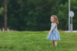 © ViDi Studio - Pretty little cute child baby girl in denim dress standing, play and have fun on green grass lawn in park. Mother, little kid daughter. Mother's Day, love family, parenthood, childhood concept.