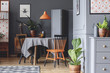 Old fashioned dining room interior with a table, chairs, orange lamp and plants