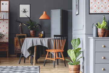 Wall Mural - Old fashioned dining room interior with a table, chairs, orange lamp and plants