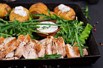 Chicken fillet cooked on a grill with a garnish of baked potatoes. Dietary meal. Healthy food.