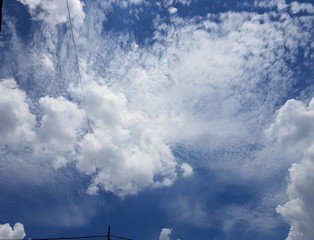 full frame background of white fluffy cumulus clouds with blue sky on clear summer's day