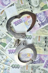 Corruption - Police handcuffs on Czech banknotes, czech crown money CZK - the concept of finance and crime