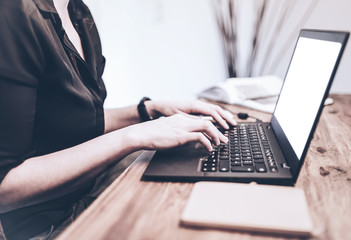 Wall Mural - close-up of young woman working on laptop computer on rustic wooden desk