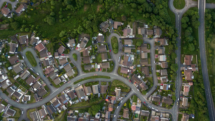 Wall Mural - top down aerial view of an urban area in a small town surrounded by trees and greenery