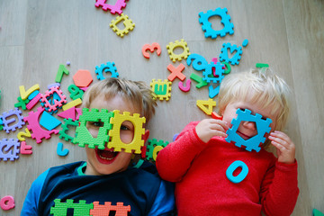 Wall Mural - happy little girl and boy play with numbers and shapes