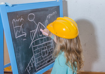 girl in a helmet paint a house on a chalk Board