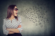 © Feodora - Woman in sunglasses talking with alphabet letters coming out of her mouth.