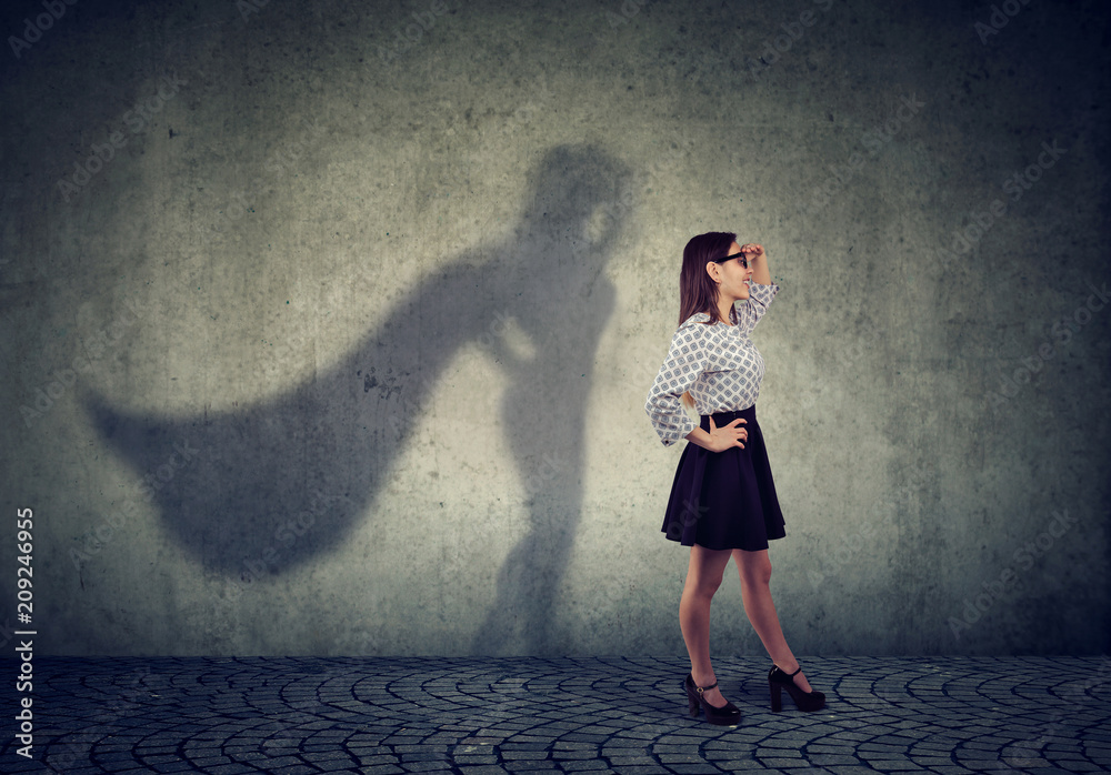 Brave young business woman posing as super hero