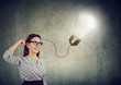© Feodora - Smiling beautiful woman having an idea with light bulb over her head