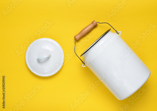 Cuadros en Lienzo Enameled milk can on yellow pastel background. Top View.