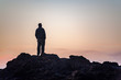 © Lauren Grabelle - Man watching sunset from a rock