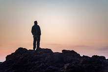 Man Watching Sunset From A Rock