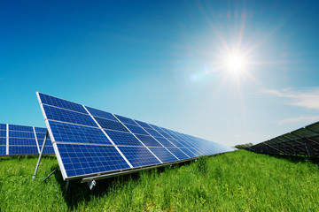 solar panel on blue sky background. green grass and cloudy sky. alternative energy concept