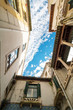 Old buildings viewed from bottom looking up with blue sky during the day in Italy