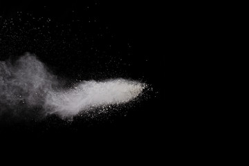 Wall Mural - freeze motion of white dust explosion on black background. stopping the movement of white powder on 