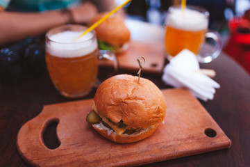 Meat burger with beer served for two in cafe. Street fast food