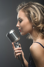 Portreit Of Sexy Young Girl Singer Singing With Silver Retro Microphone
