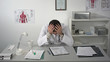 © fancystudio - Doctor tired and holding his head at medical cabinet