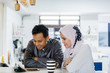 © Danon - A young Muslim Malay couple sit at a table top counter and enjoy a coffee early in the morning when they break fast.