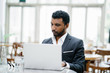 © Danon - Portrait of an Indian man in a 3-piece suit working on his notebook computer during the day.