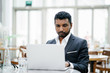 © Danon - Portrait of an Indian man in a 3-piece suit working on his notebook computer during the day.