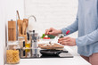 © LIGHTFIELD STUDIOS - cropped shot of woman pouring spices onto food cooking on frying pan