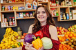 © AS Photo Family - Girl in red holding different vegetables on fruits store.