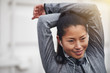 © Flamingo Images - Sporty young Asian woman listening to music outside while stretc