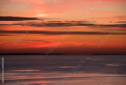 Plagát Red sky at sunset over ocean with thin dark clouds
