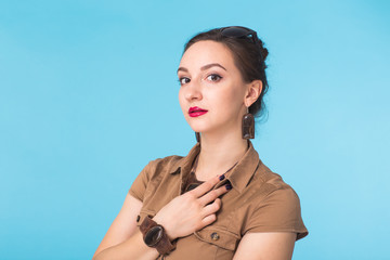 Beauty fashion female portrait. Confident young woman on blue wall background.