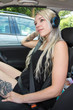 Junge blonde Frau in Auto mit Kopfhörern