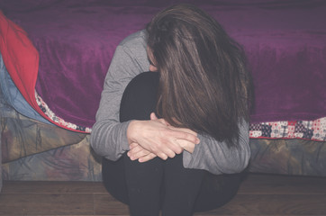 Wall Mural - Depressed and lonely girl abused as young sitting alone in her room feeling miserable and anxiety cry over her life, dark image