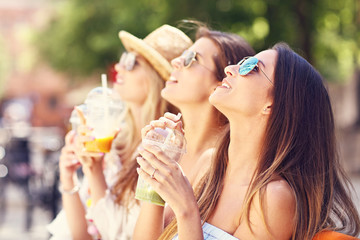 Wall Mural - Happy girl friends hanging out in the city in summer