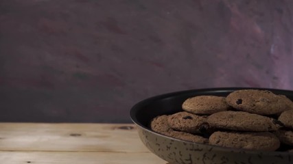 Poster - Oat biscuits raisins in baking dishes, rotation 360 degrees. Beautiful dark-red background.