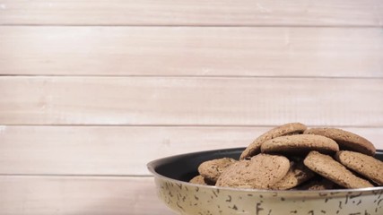 Poster - Oat biscuits raisins in baking dishes, rotation 360 degrees. Beautiful wooden background.