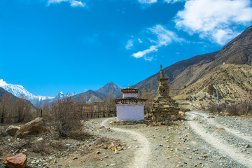 Two stone stupas on a mountain road in Nepal.