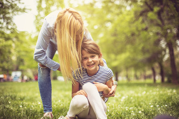 Wall Mural - Happy mother with daughter on meadow.