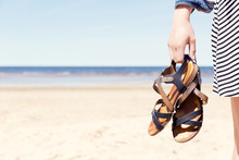 Woman On The Beach Holding Her Sandals At Sunny Summer Day