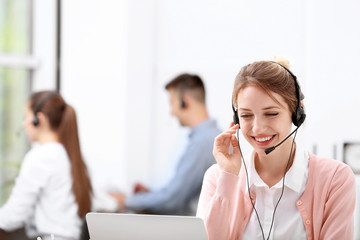 Poster - Young female receptionist with headset in office