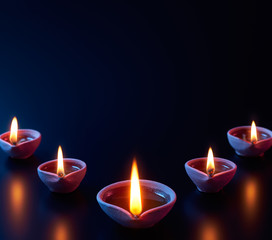 Wall Mural - Traditional clay diya lamps lit during Diwali celebration