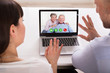 © Andrey Popov - Couple Video Conferencing On Laptop