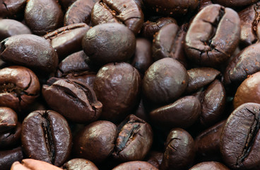 Roasted black coffee beans close up macro shot for background.