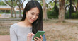 © leungchopan - Woman using mobile phone in the park