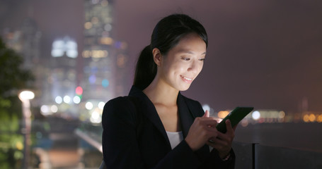 Wall Mural - Young Businesswoman use of cellphone at night