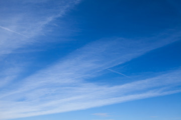 blue sky with striped clouds. contrail.