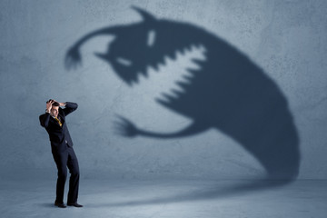 Wall Mural - Business man afraid of his own shadow monster concept on grungy background