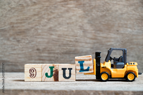 Poster Toy forklift hold block l to complete word 9 jul on wood background (Concept for