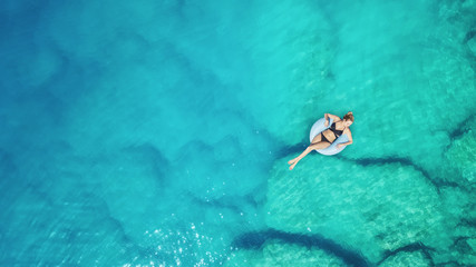 Wall Mural - aerial view at the girl on sea surface. beautiful composition at the summer time