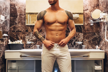 Wall Mural - Young Muscular Man Staying in Bathroom