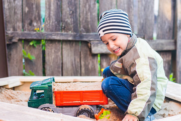 Wall Mural - boy playing with the car in the sandbox